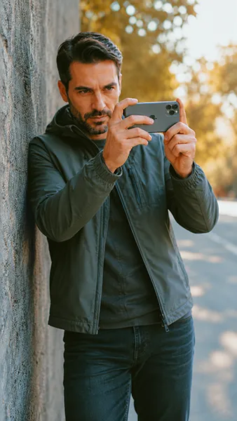 Man taking leaning against a wall showing how to take a better iPhone photos