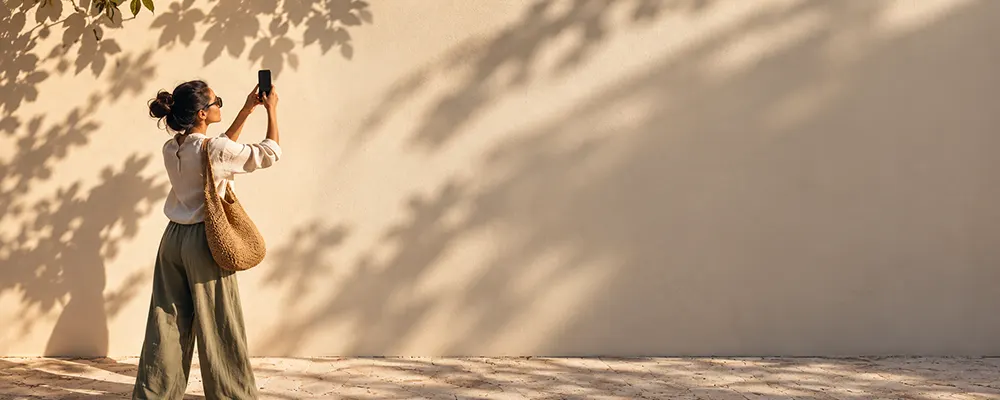 Girl taking a picture of a wall using negative space phone photography